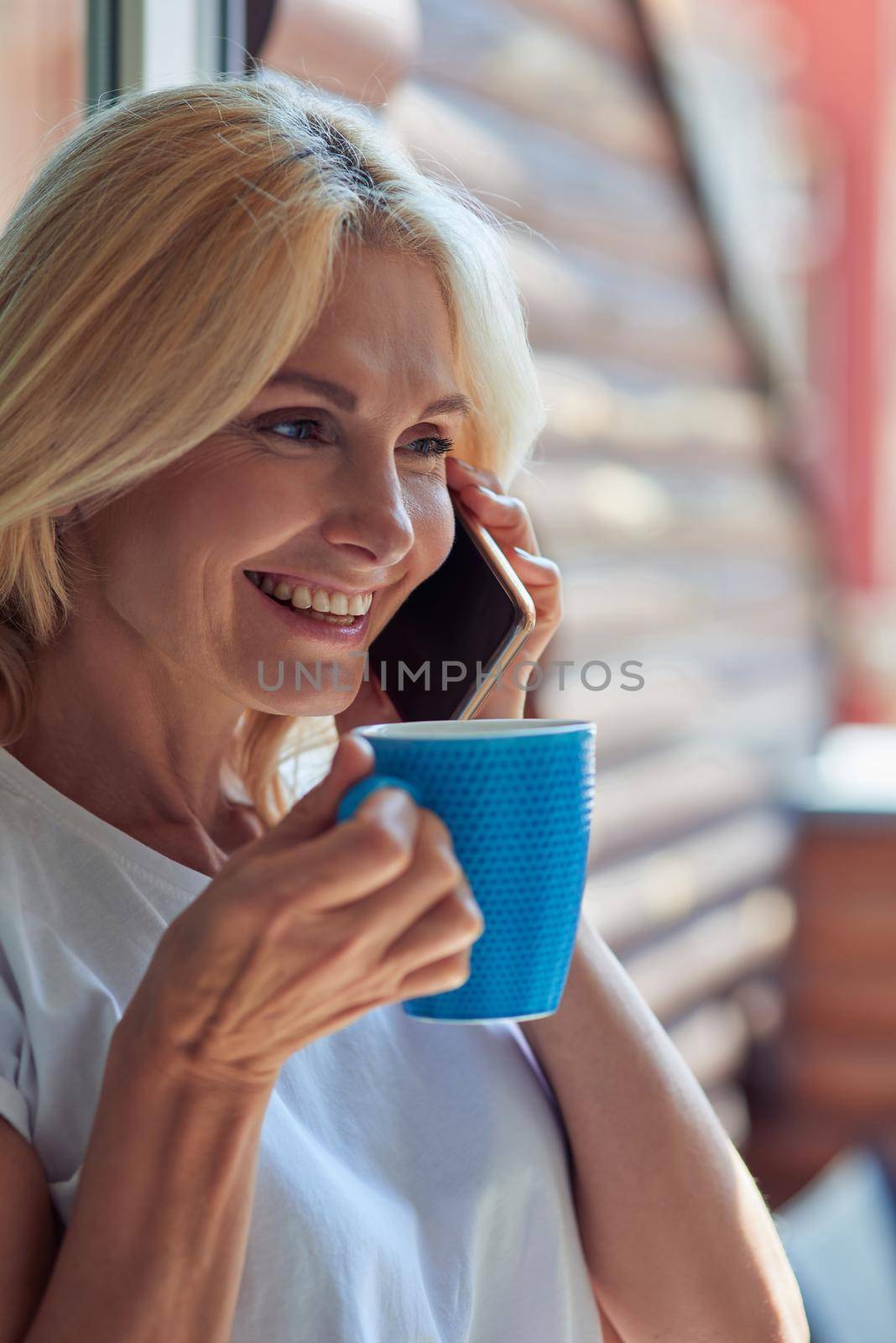 Portrait of middle aged caucasian woman talking on phone by friendsstock