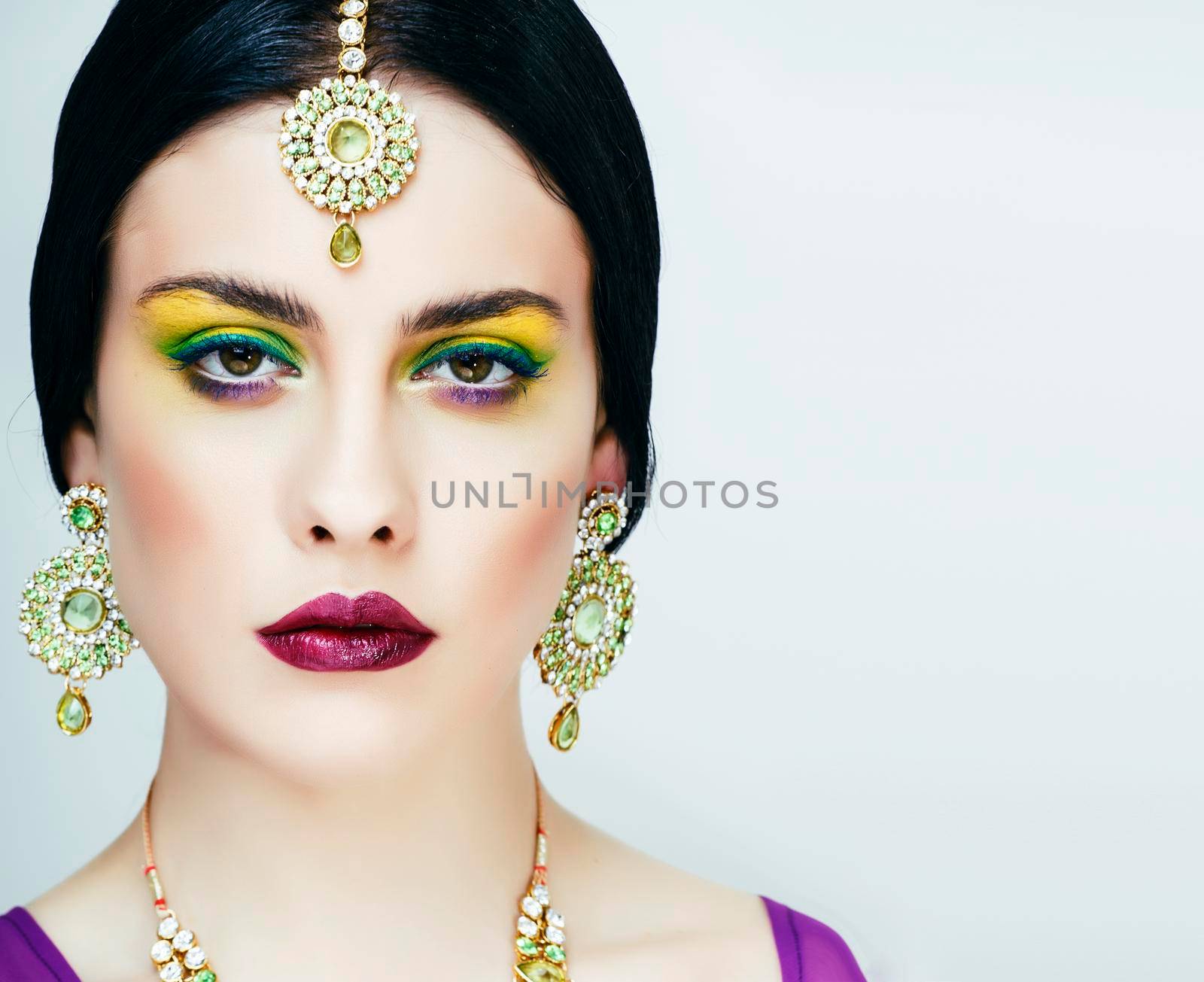 young pretty caucasian woman like indian in ethnic jewelry closeup on white, bridal bright makeup fashion people close up