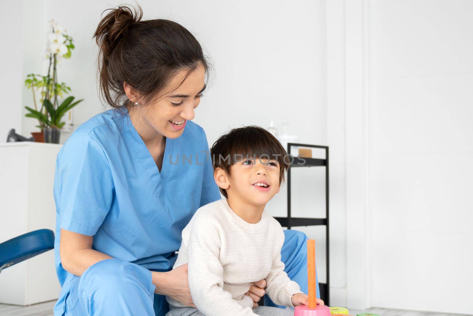 Physical therapist playing with a boy who has cerebral palsy. High quality photo.