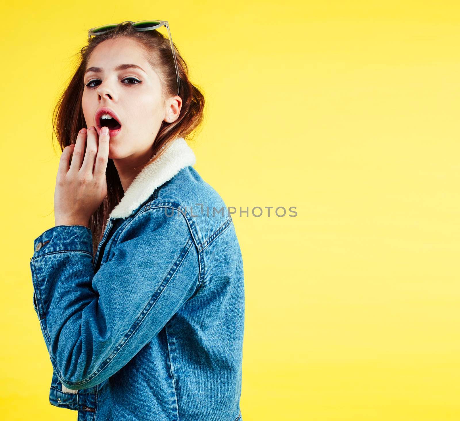 lifestyle people concept: pretty young school teenage girl having fun happy smiling on yellow background close up