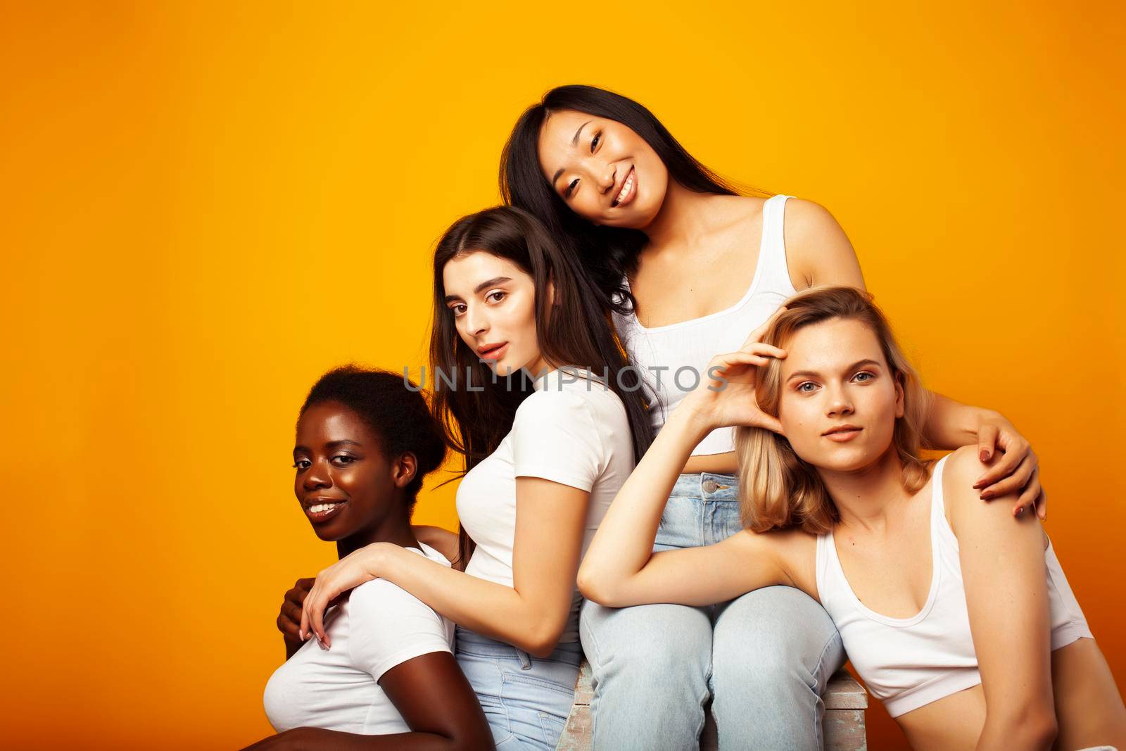 diverse multi nation girls group, teenage friends company cheerful having fun, happy smiling, cute posing on yellow background, lifestyle people concept, african-american, asian and caucasian by JordanJ