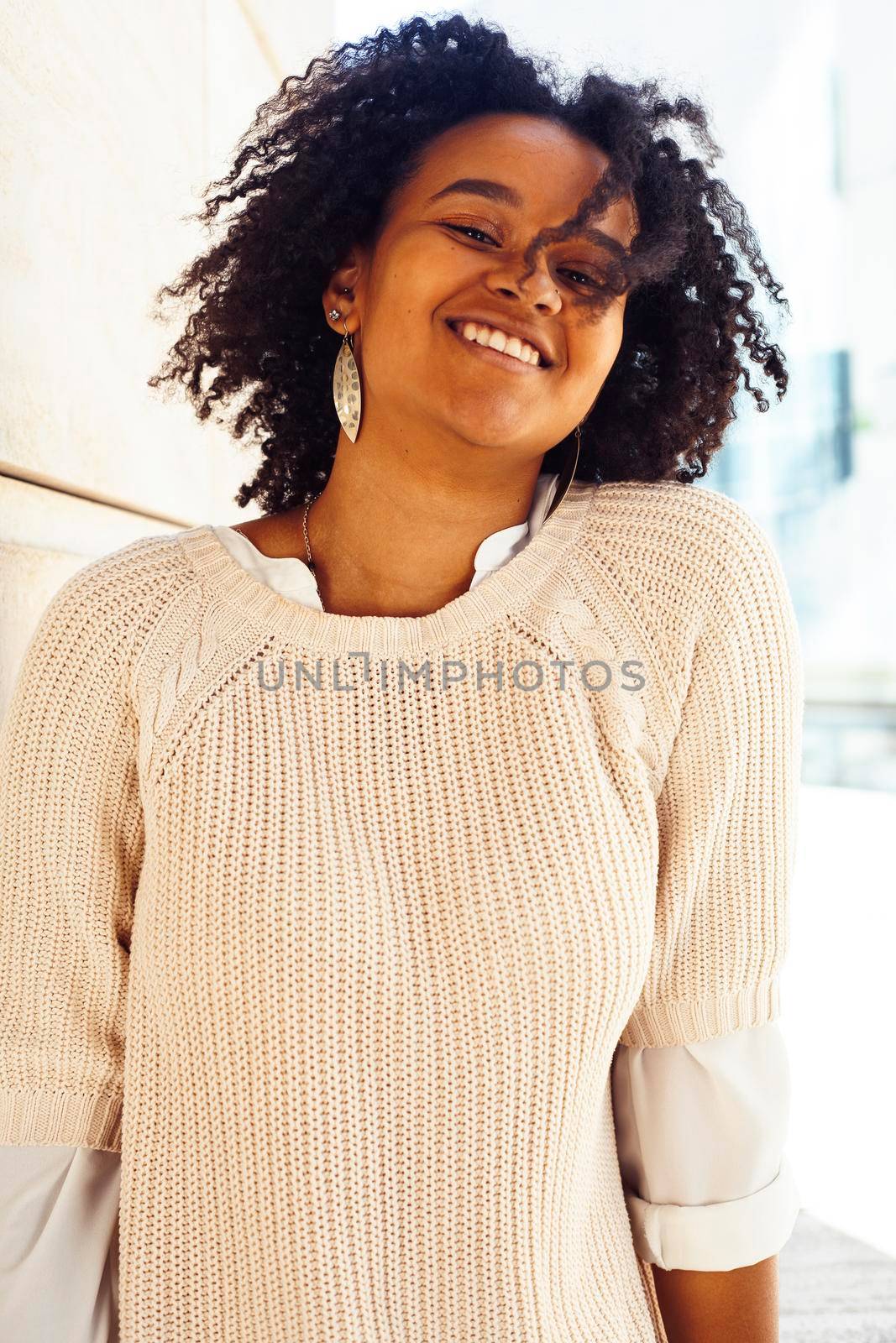 young pretty african girl posing cheerful on city background, lifestyle outdoor people concept close up