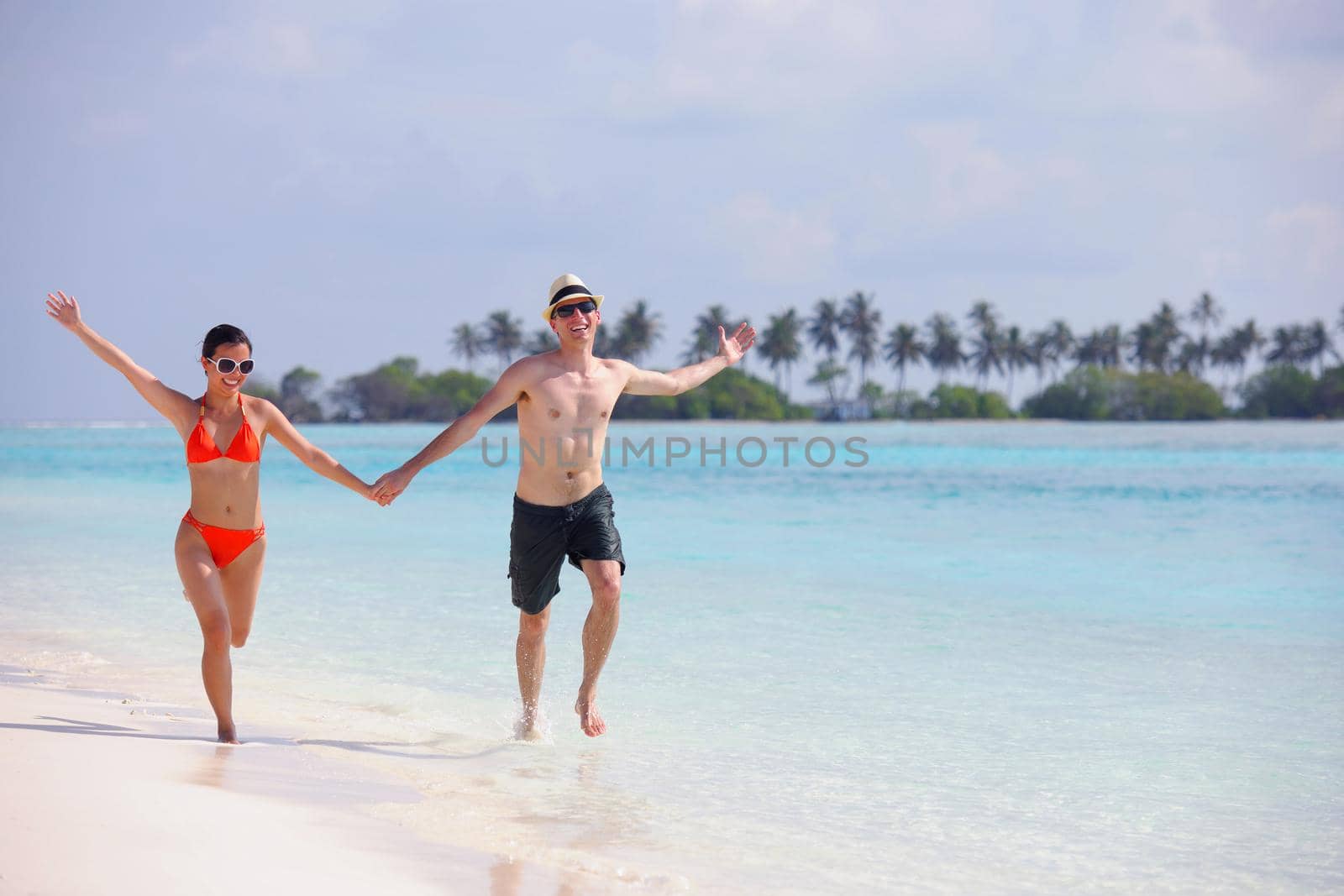 happy young couple have fun on beach by dotshock