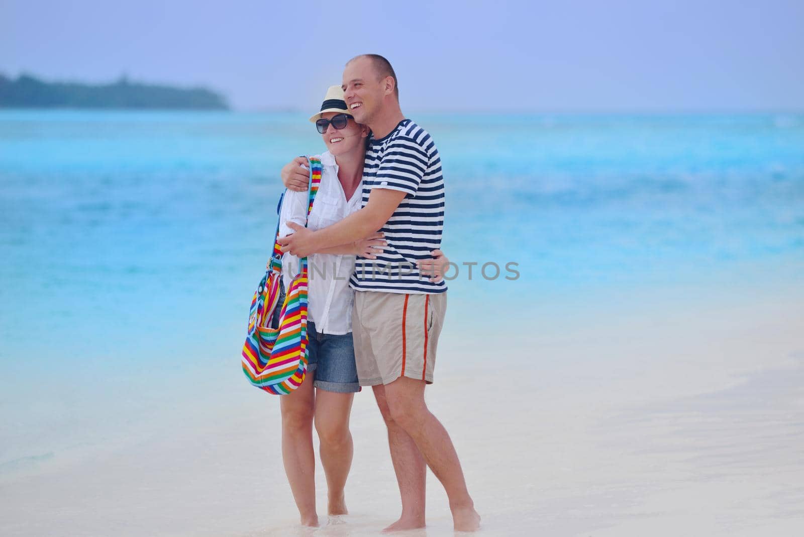 happy young couple have fun on beach by dotshock