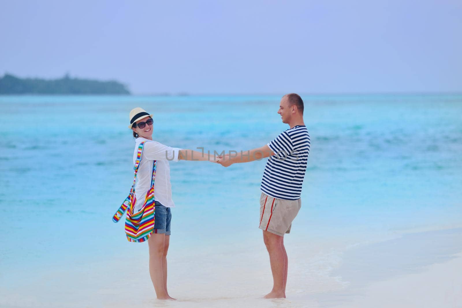 happy young couple have fun on beach by dotshock