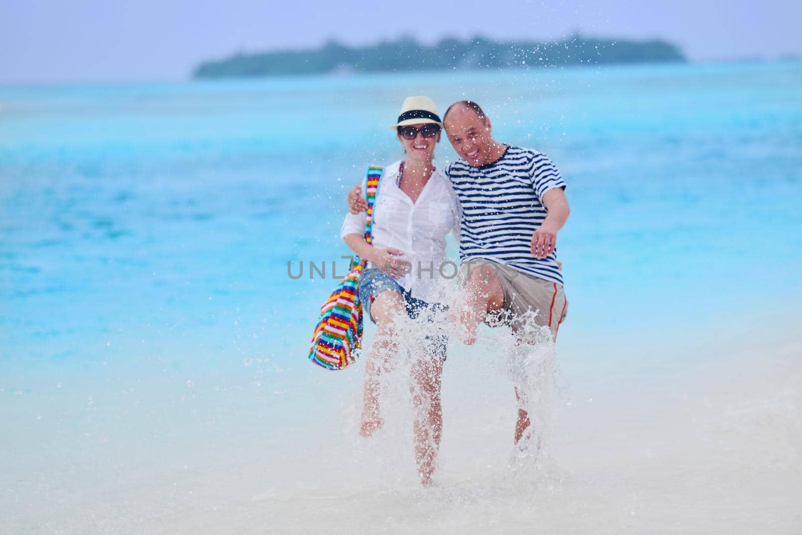 happy young couple have fun on beach by dotshock