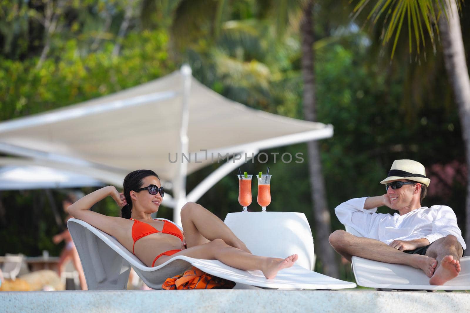 happy young couple relax and take fresh drink at summer vacation