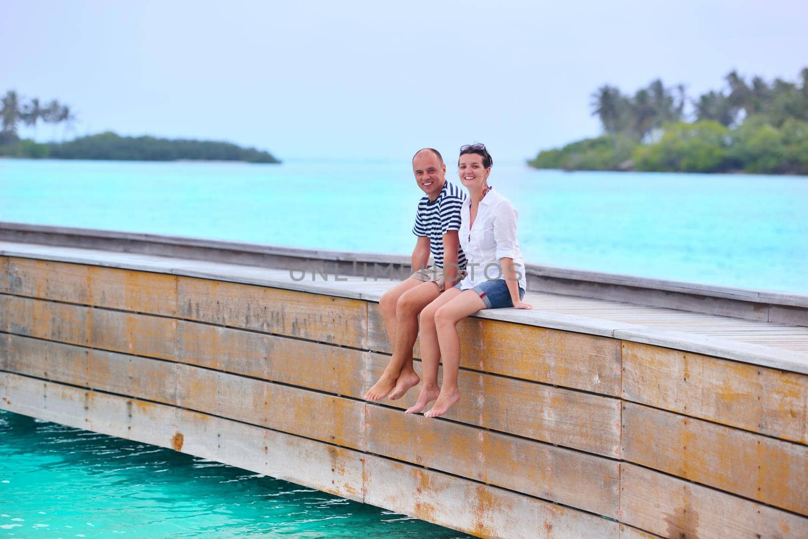 happy young couple have fun on beach by dotshock