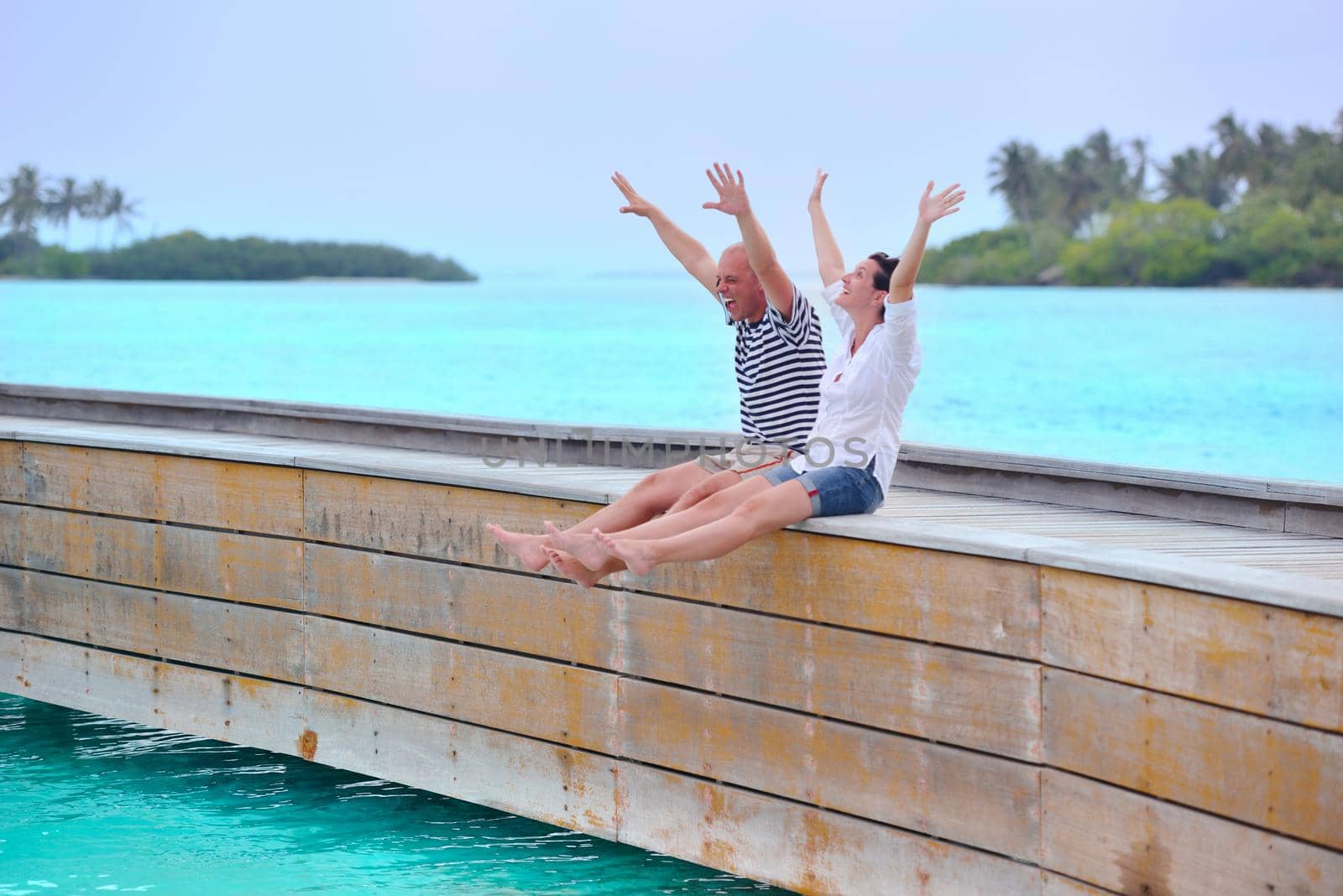 happy young couple have fun on beach by dotshock