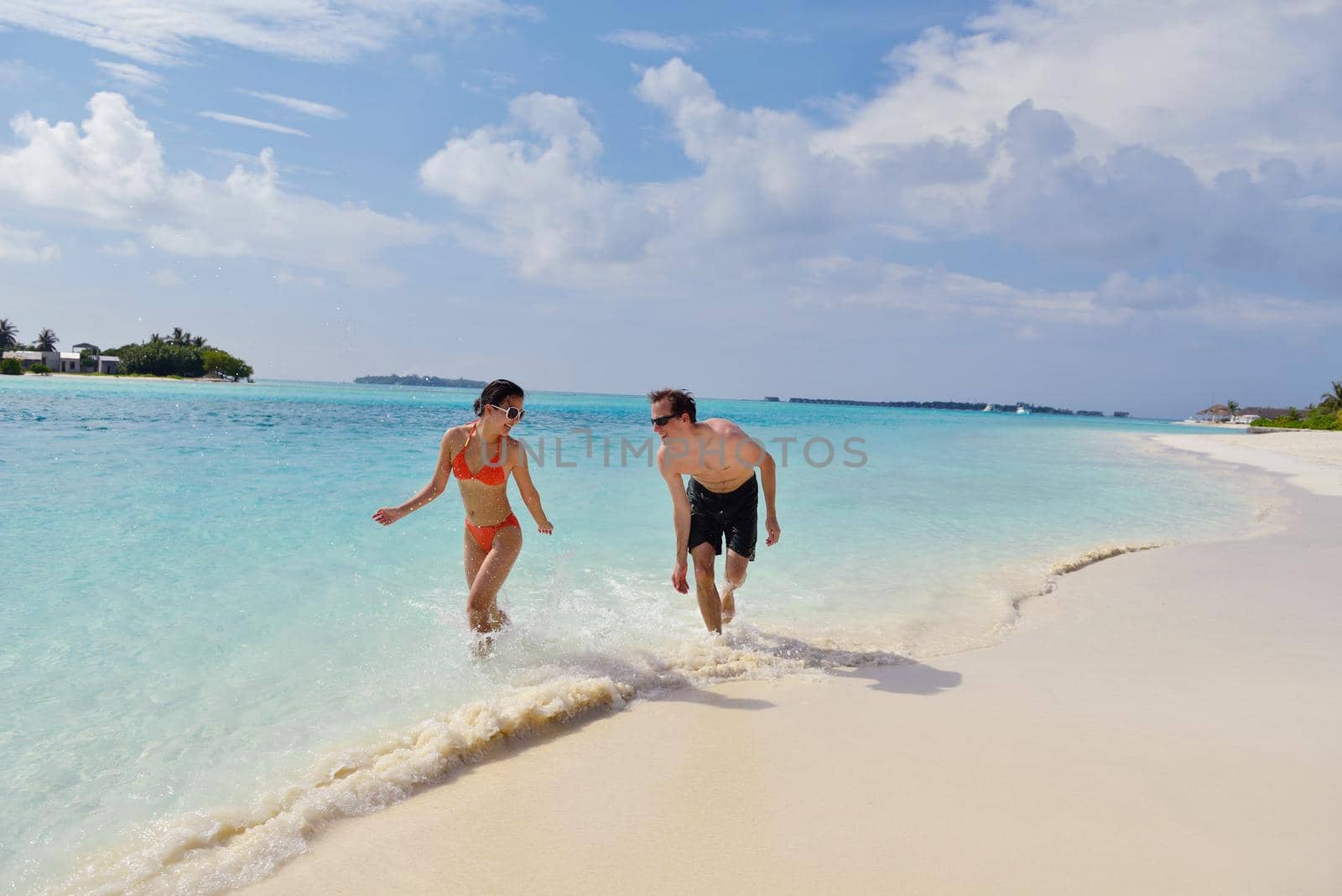 happy young couple have fun on beach by dotshock