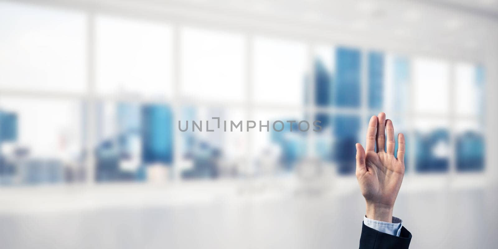 Close of businesswoman hand touching screen with palm and office at background