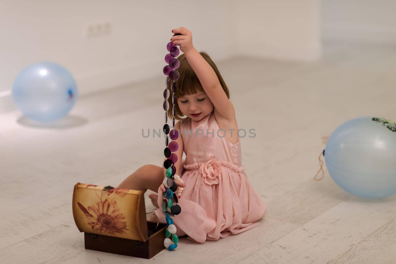 little girl enjoying while playing with mother's jewelry by dotshock