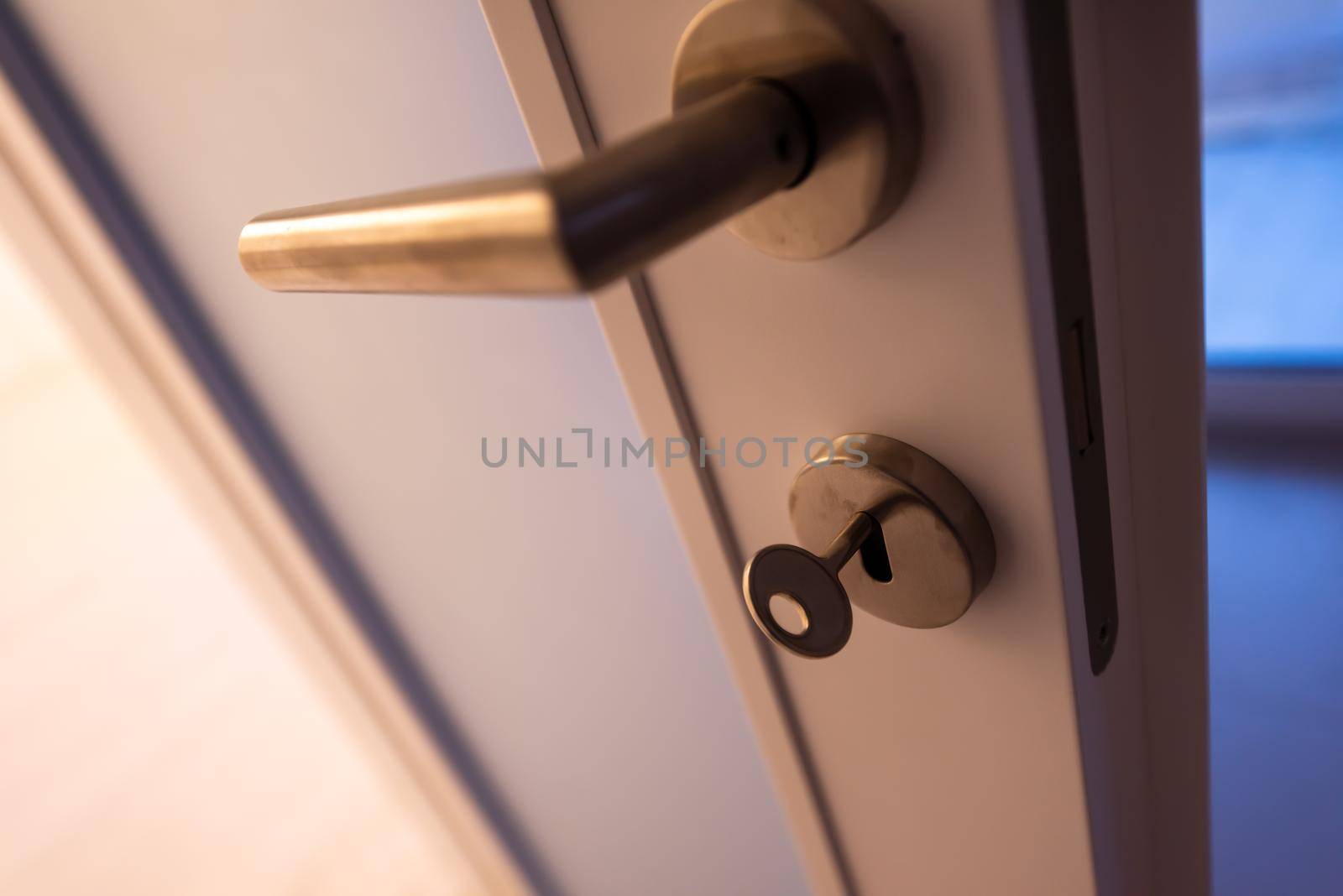 close up of door handle in room interior with Key in the lock