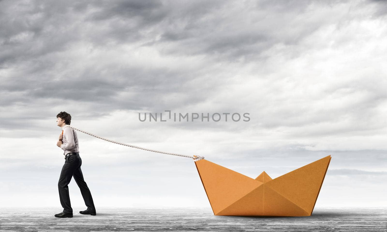 Successful businessman pulling with rope paper boat