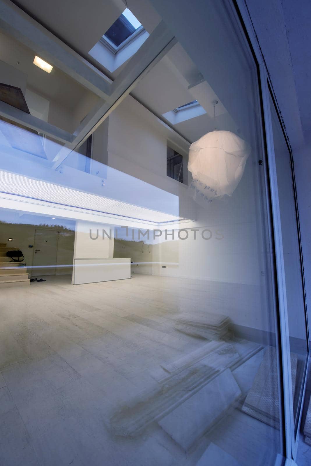 outside view trough window on interior of a luxury stylish modern open space design two level apartment with white walls