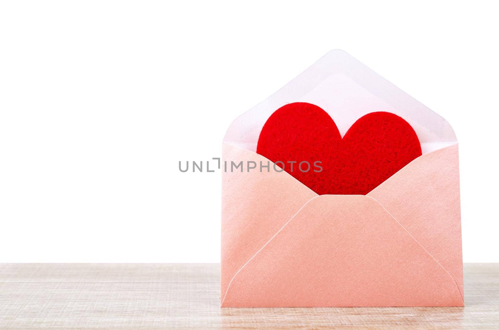 Fabric red heart shape in pink envelupe on wooden background, Valentine concept.