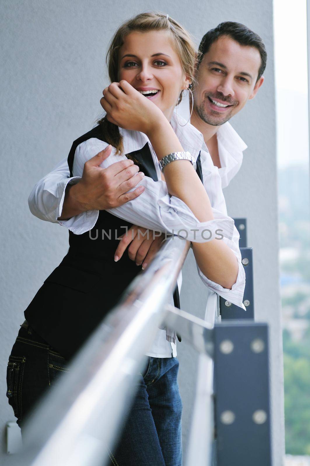 romantic happy couple relax and have fun at balcony in their new home apartment