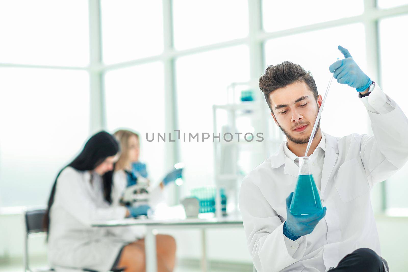 close up. the young scientist makes the analysis of the liquid in the flask by SmartPhotoLab