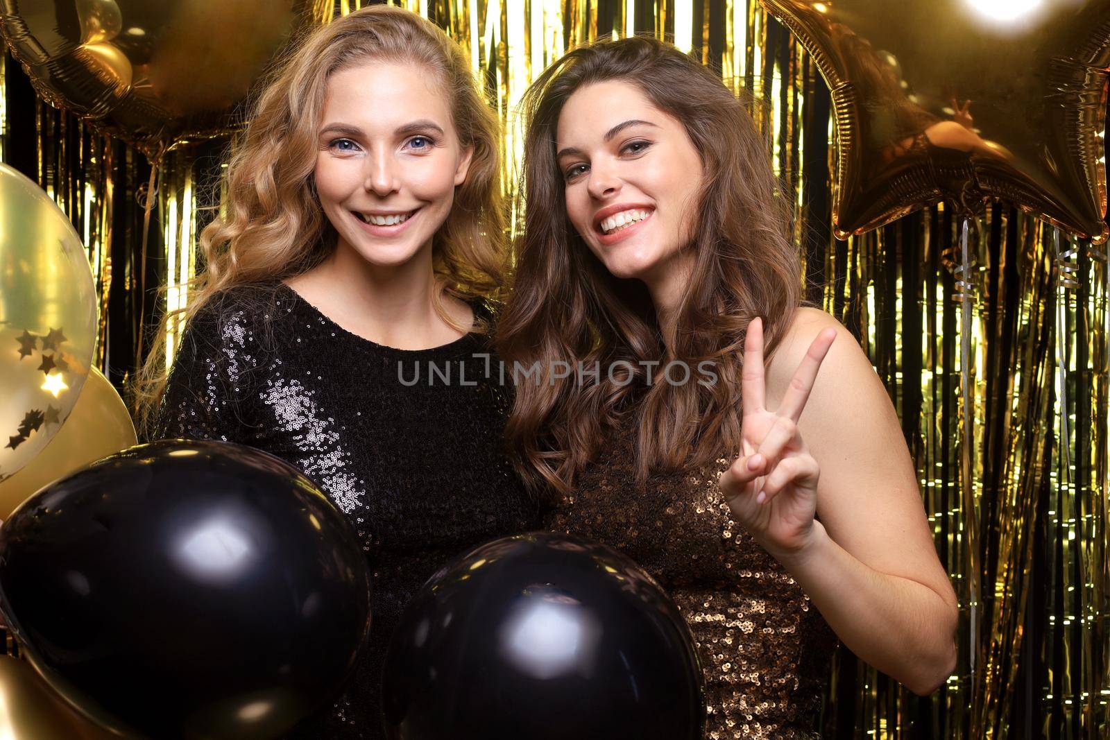 Beautiful girls celebrating New Year. Gorgeous smiling young women enjoying party celebration, having fun together
