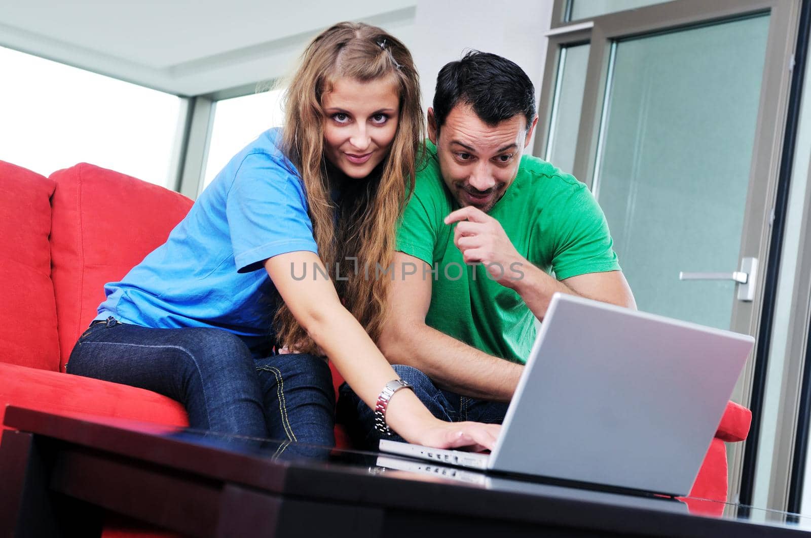 happy couple have fun and work on laptop at home by dotshock