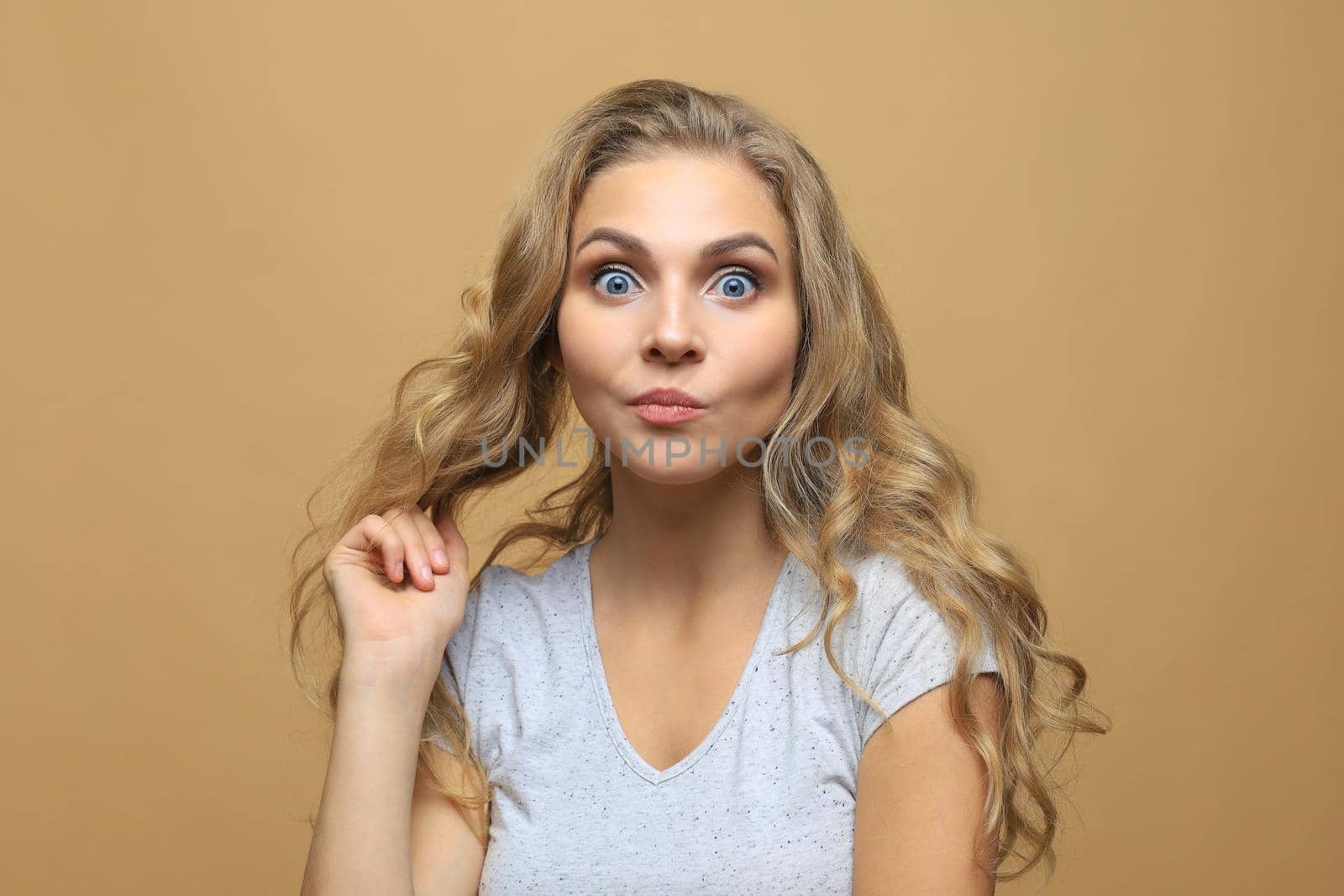 Portrait of young beautiful cheerful girl smiling looking at camera over beige background