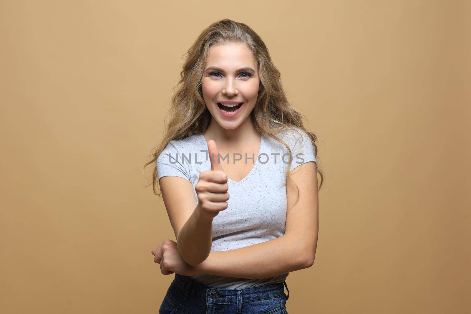 Young happy cheerful woman showing thumb up