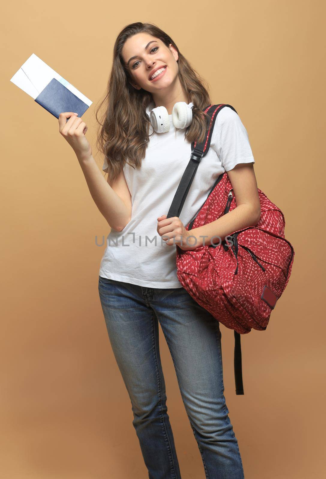 Woman traveler with backpack, passport and ticket on beige background