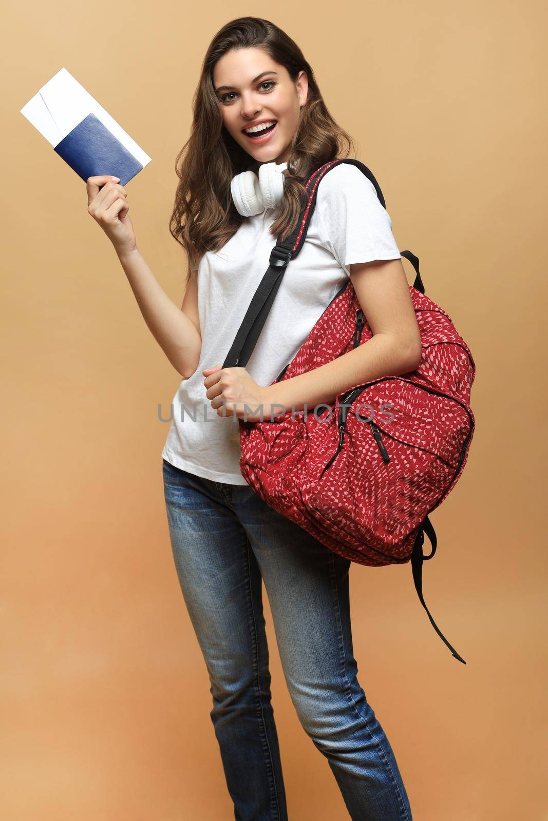 Woman traveler with backpack, passport and ticket on beige background