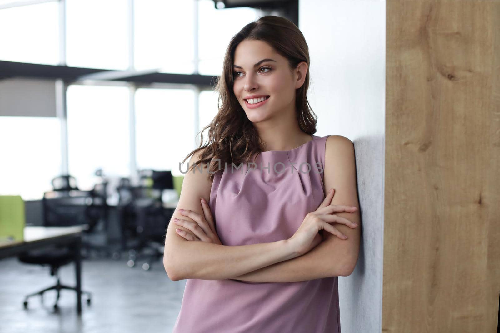 Attractive business woman smiling while standing in the office