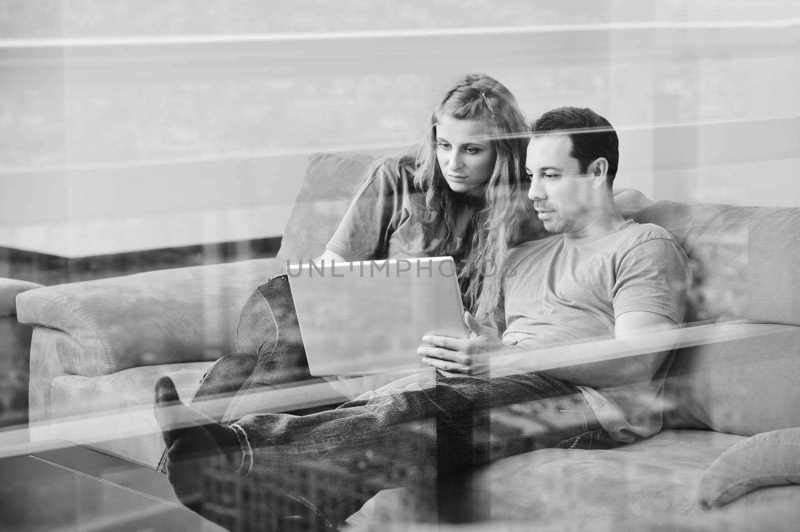 happy young couple have fun and relax at comfort bright apartment and work on laptop computer