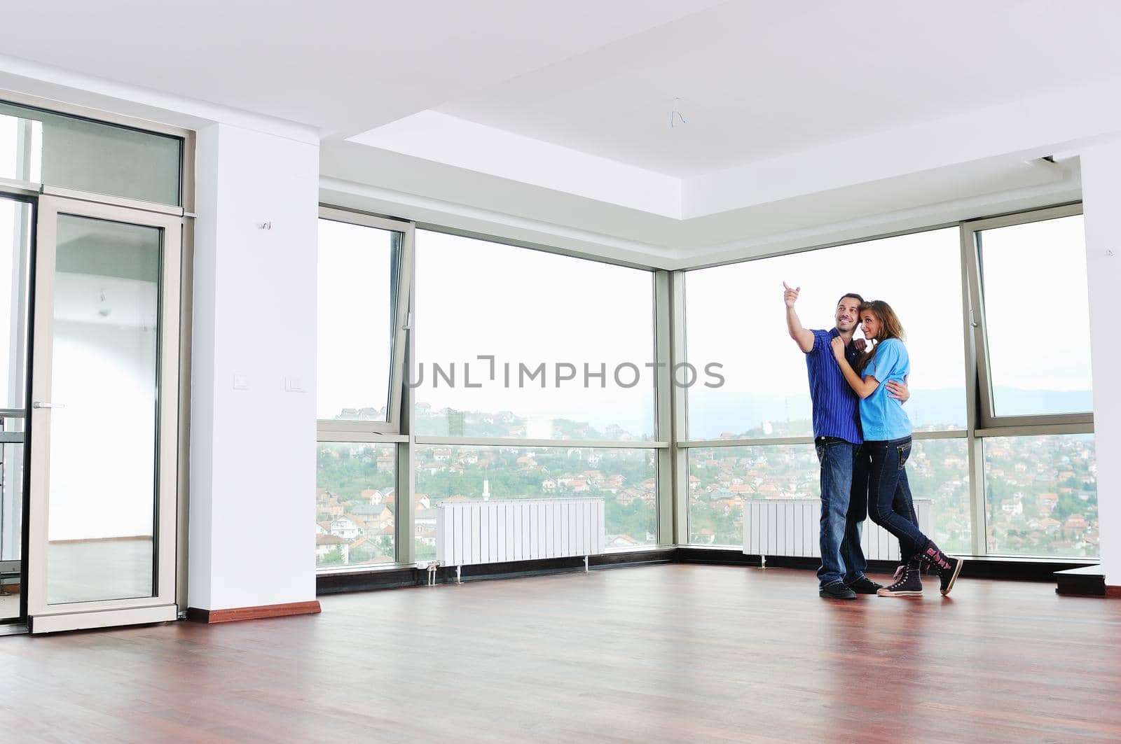 happy couple in empty apartment by dotshock