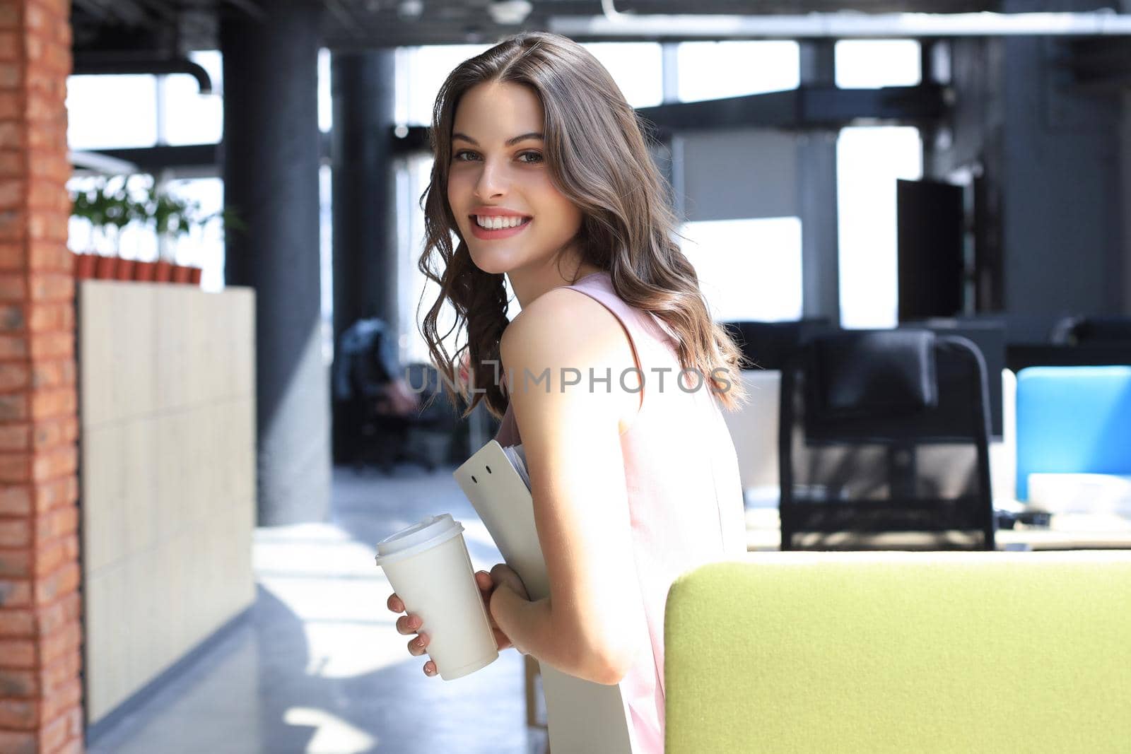 Attractive business woman smiling while standing in the office