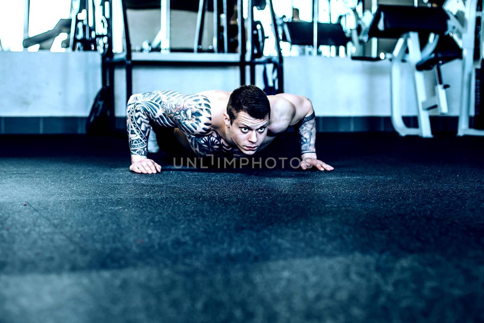 attractive muscular man in the fitness room. photo with space for text