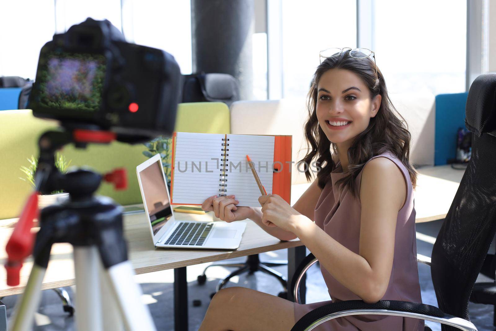 Beautiful young woman talking and smiling while making new video for her blog