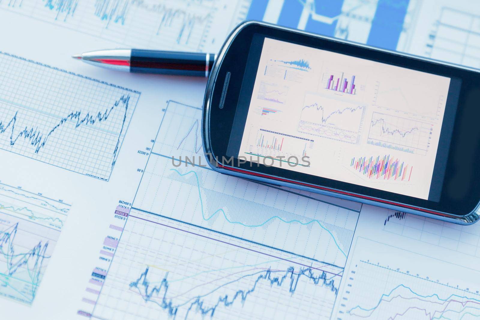 mobile phones and charts of financial growth on the desktop . business concept