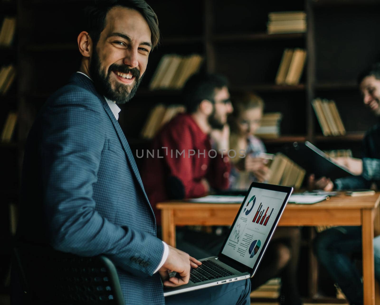 accountant works with financial charts on the laptop in the office on the background of a successful business team