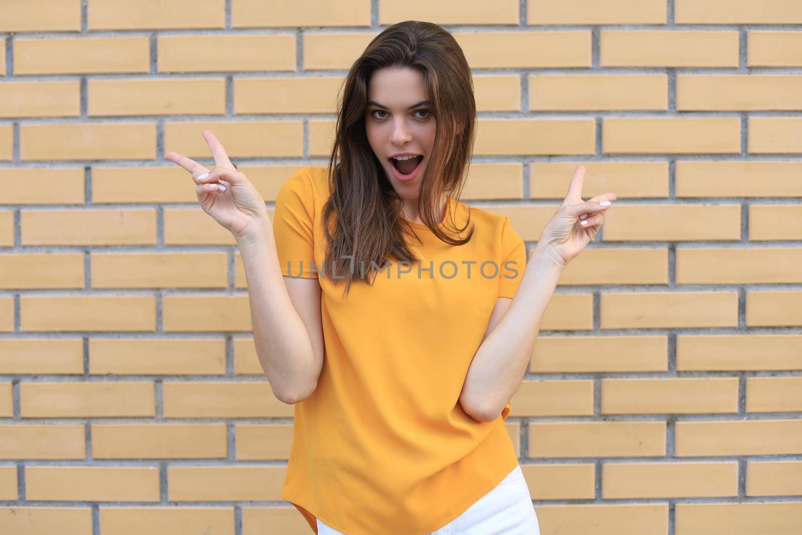 Beautiful smiling brunette model dressed in summer hipster clothes. Funny and positive woman having fun