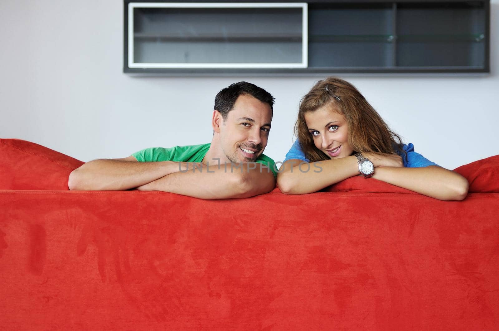 happy couple relax on red sofa by dotshock