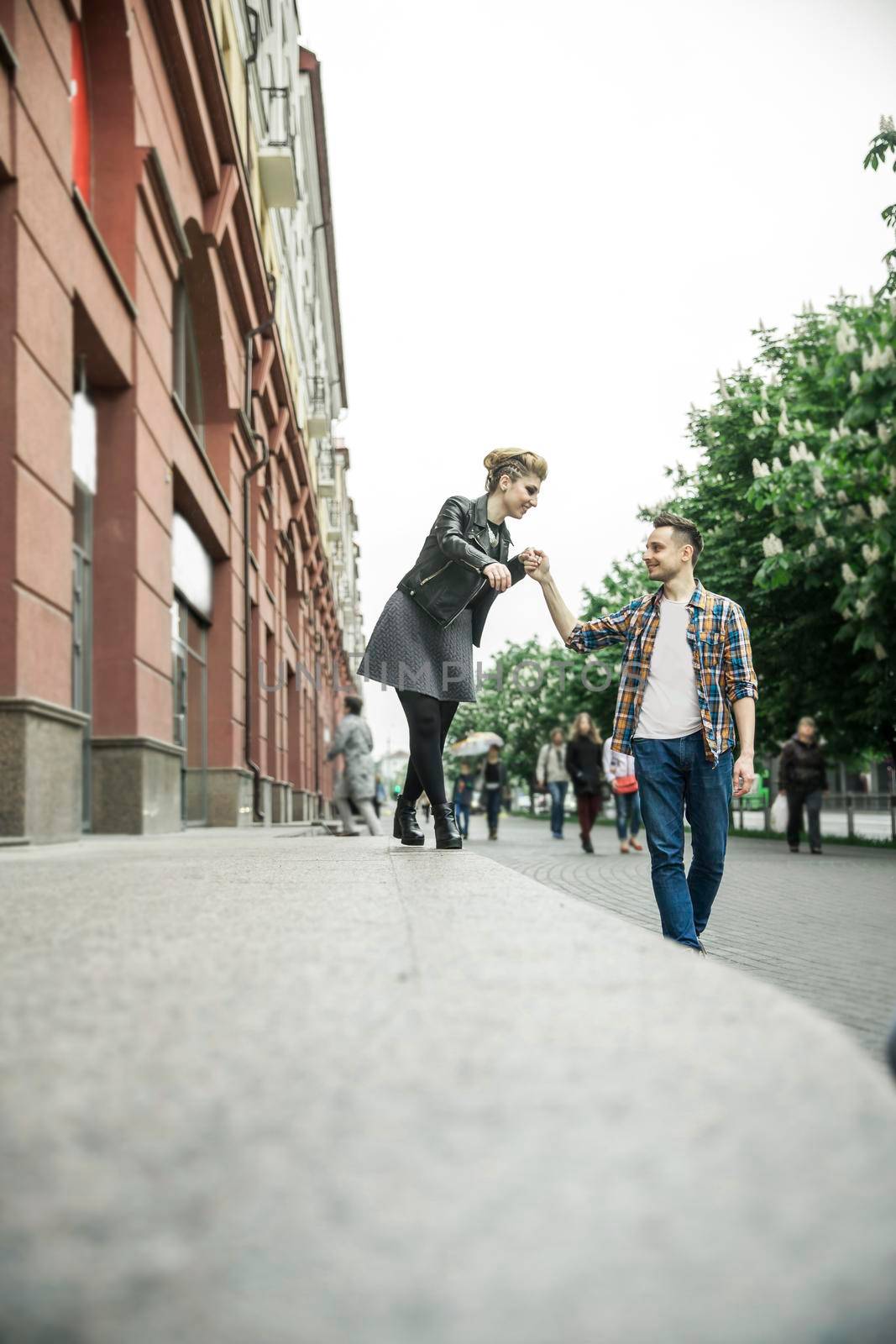 happy loving couple walking down the street of a big city by SmartPhotoLab