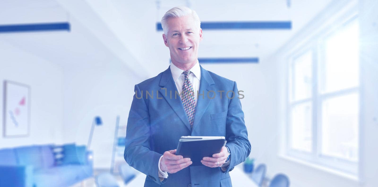 Portrait of senior businessman using tablet in front of his modern office