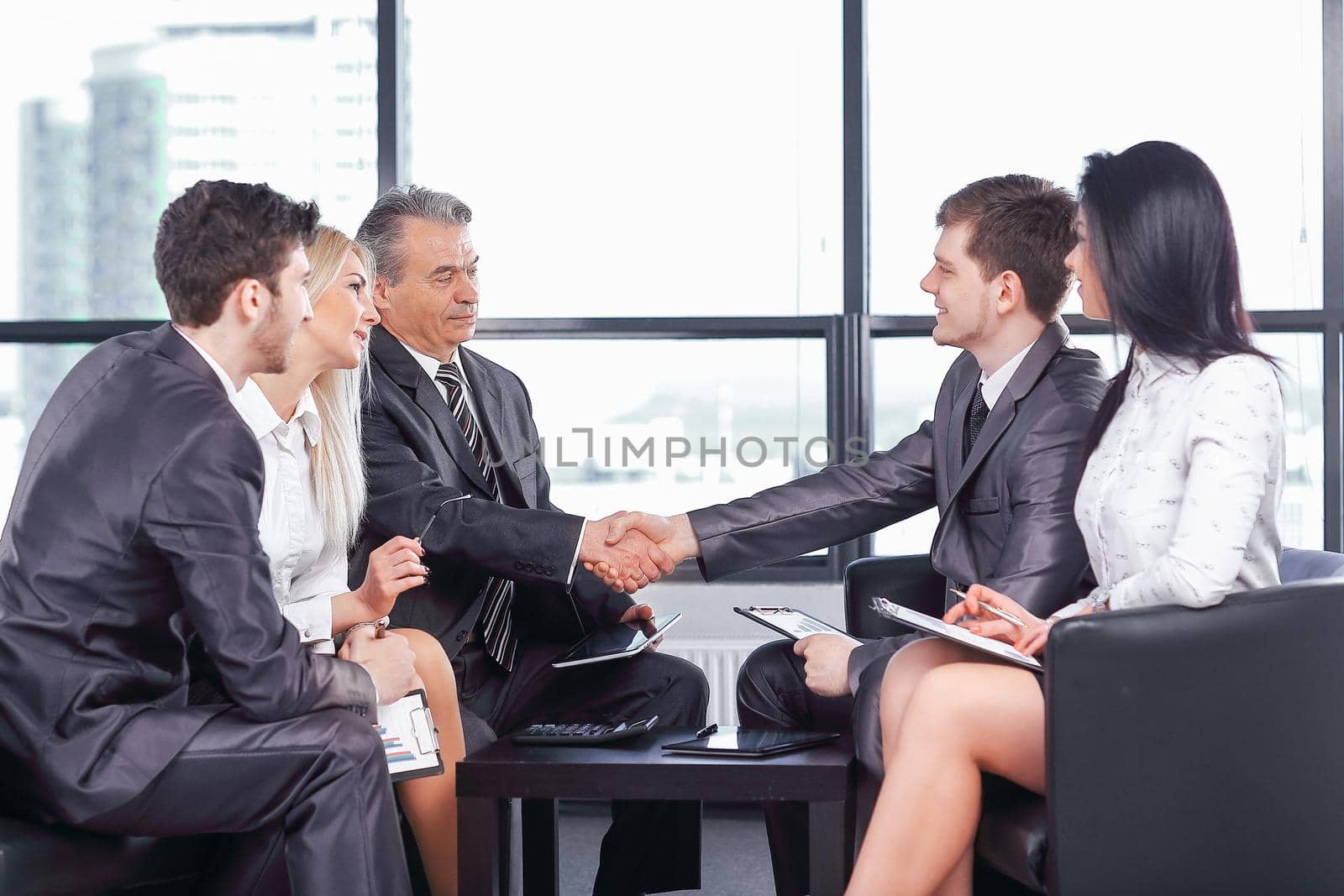 usiness handshake at a working meeting in the office by SmartPhotoLab