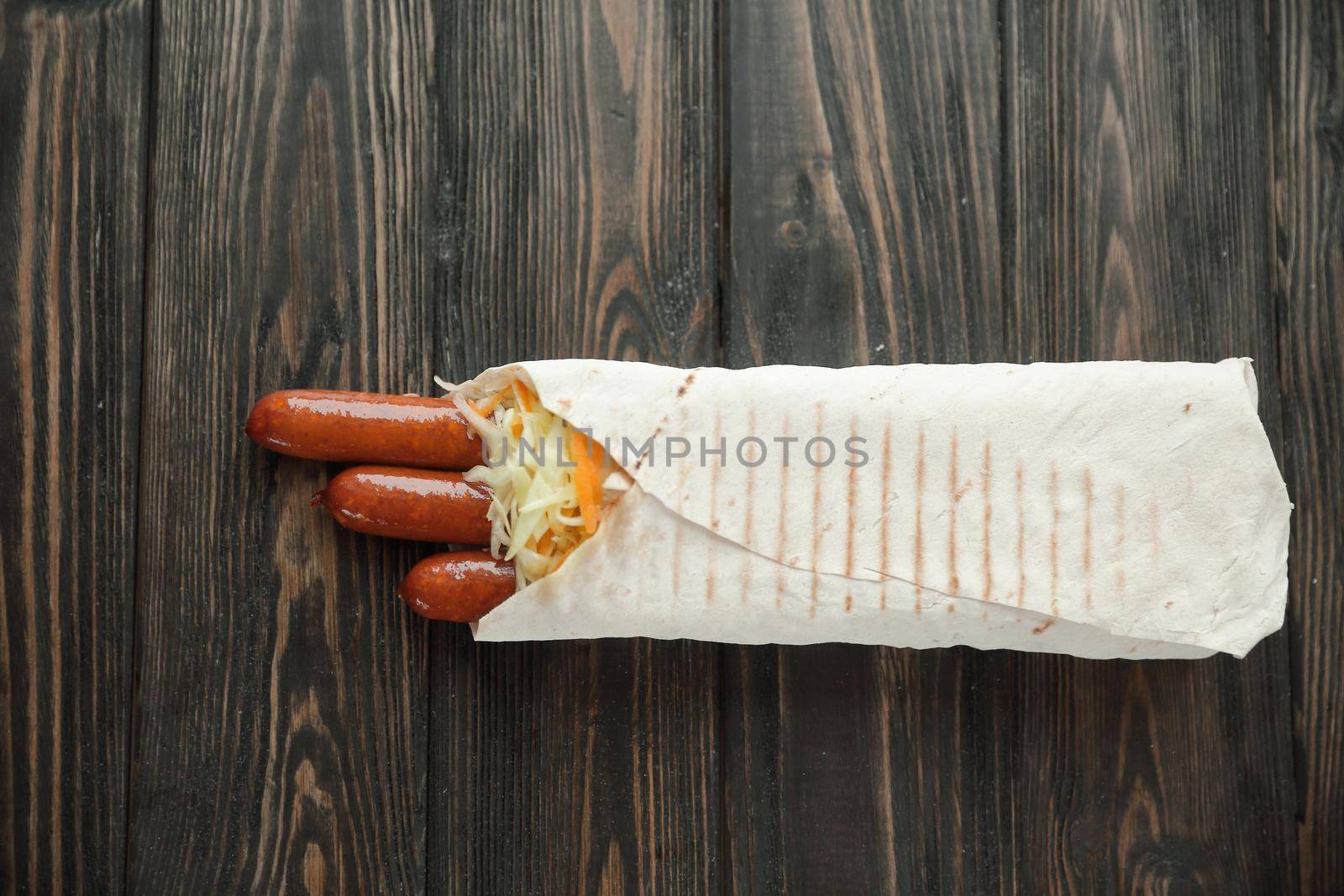 spicy sausages in pita bread on wooden background.photo with copy space.