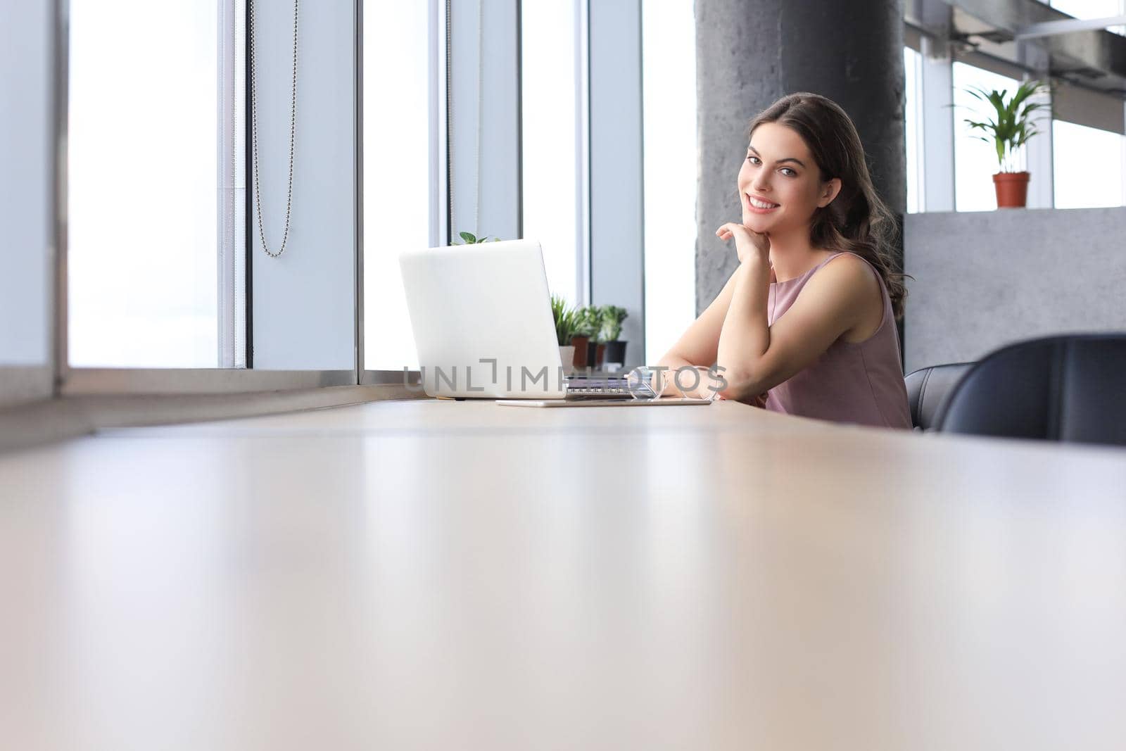 Beautiful business woman in smart casual wear working on laptop in the office.