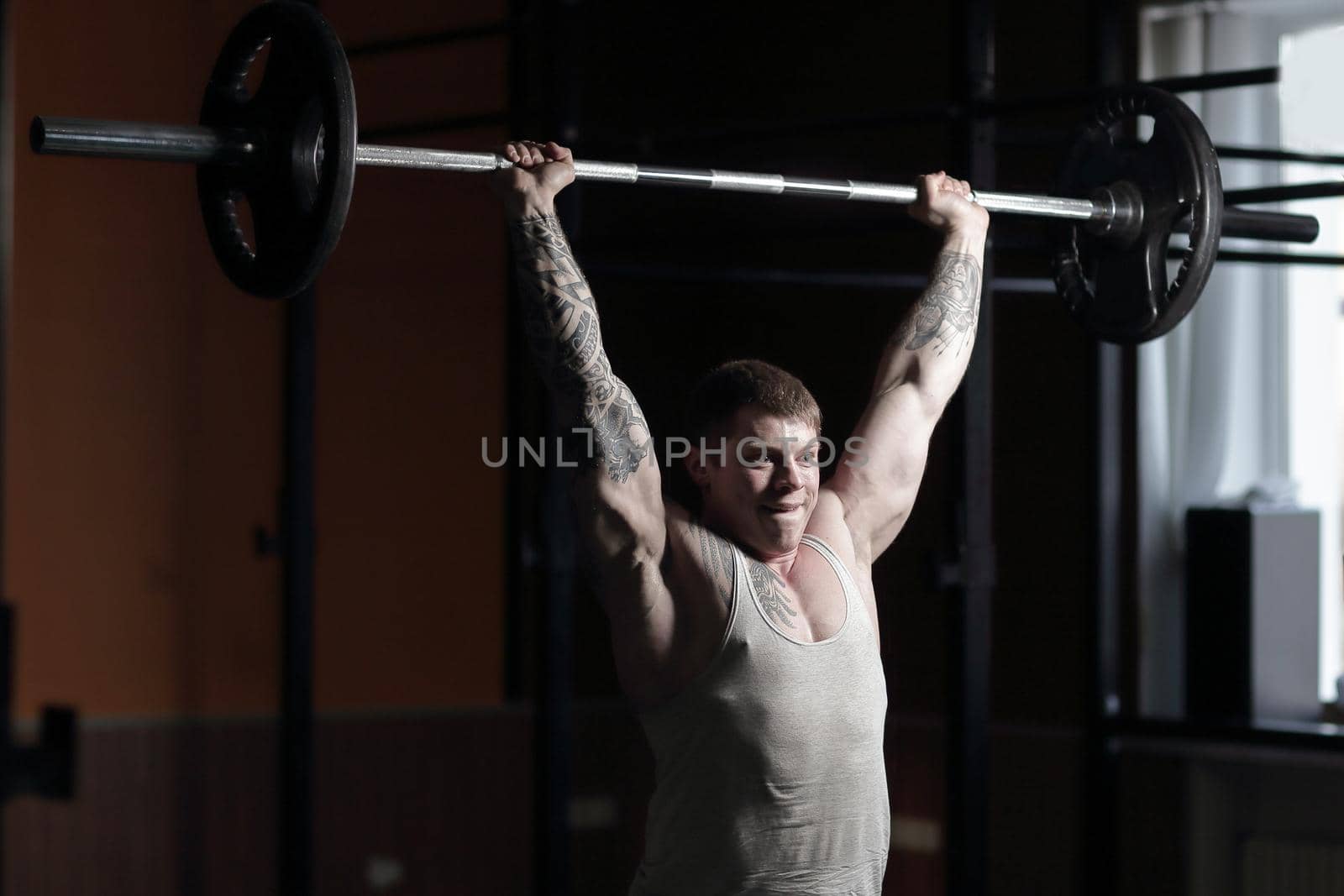 male bodybuilder doing exercises with a barbell .photo with copy space