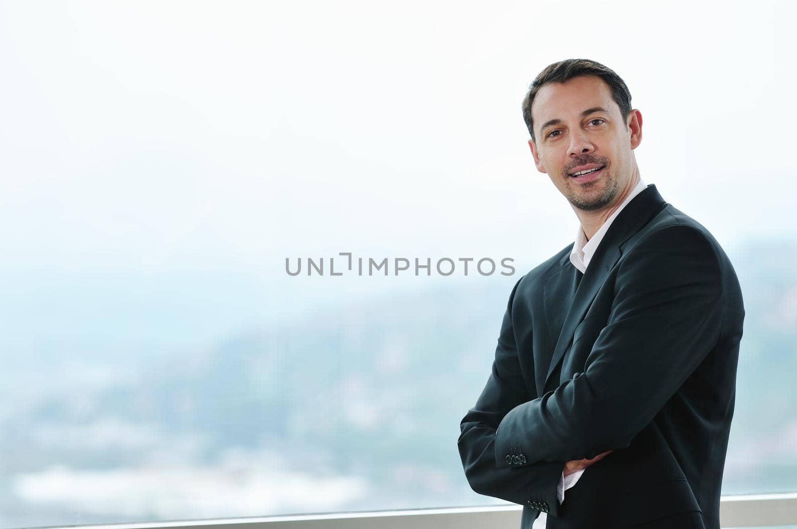 happy young business man portrait in suit  with isolated blured background 