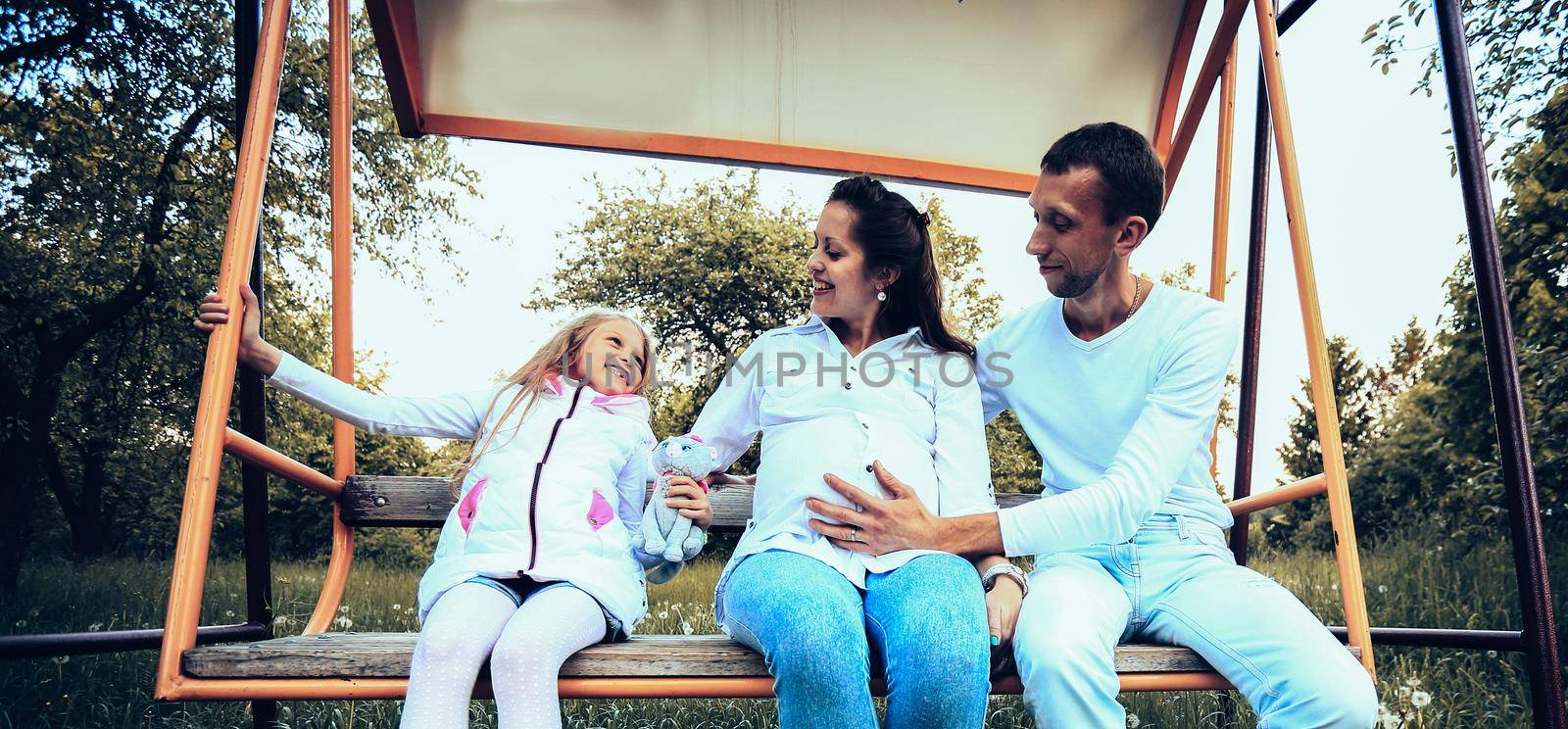 happy family on the swings in the garden on Sunday by SmartPhotoLab