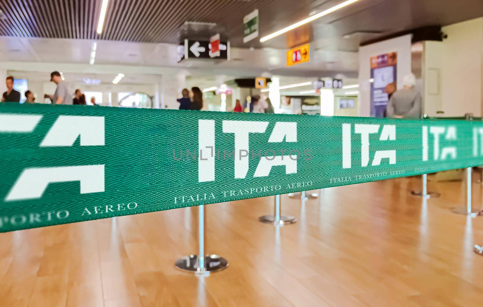 Fiumicino, Italy, July 2021: green ribbon barrier with the ITA airline logo inside the Leonardo da Vinci airport in Rome, Italy. ITA is the new Italian flag carrier starting from 15 October 2021