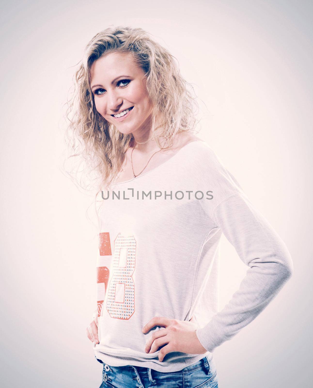 beautiful young woman blonde t-shirt and jeans on white background.