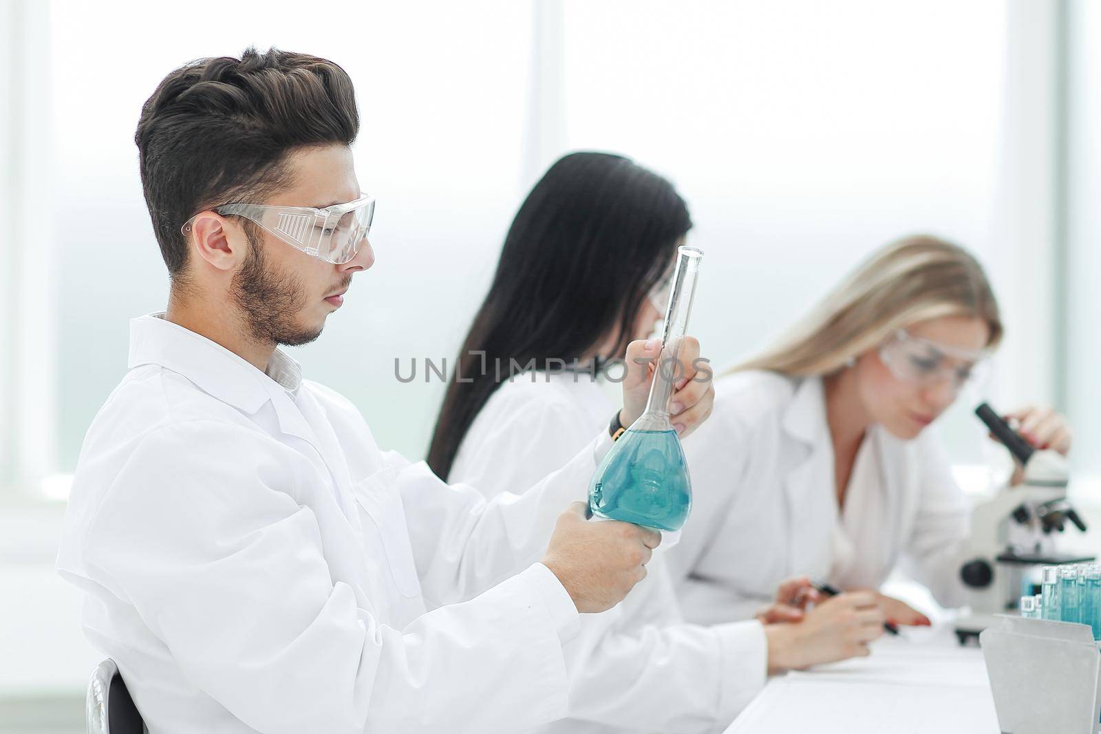 group of scientists examines the liquid in the laboratory. science and health