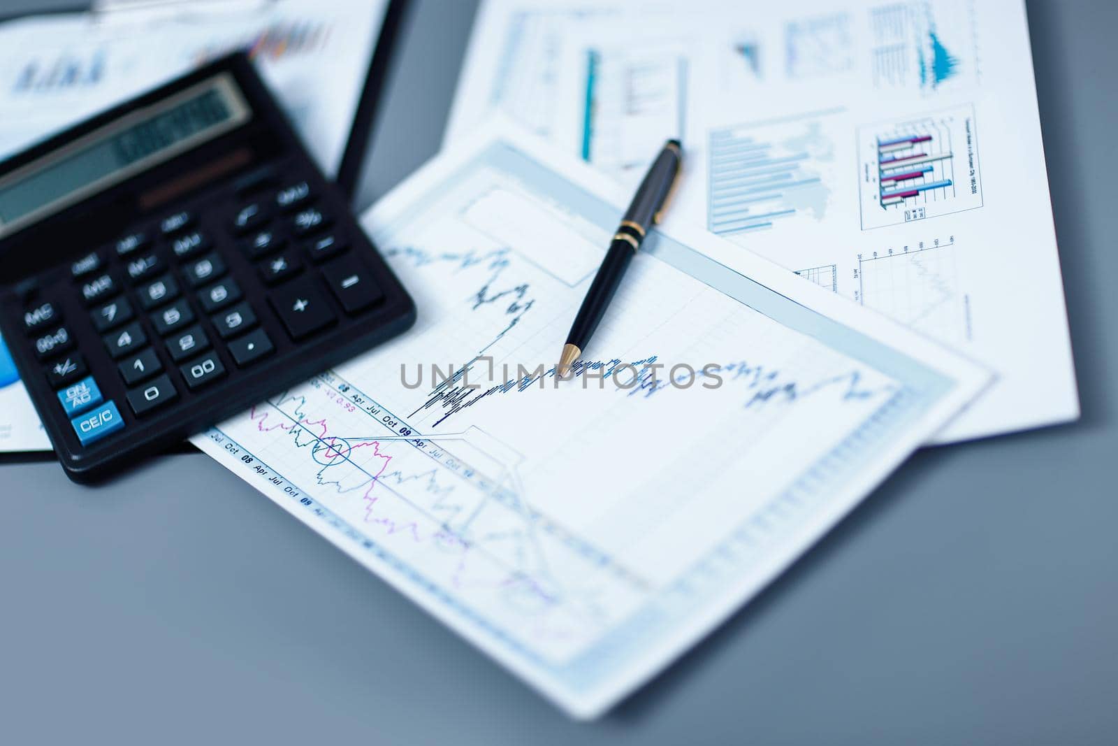 close up.pen, financial chart and calculator on the businessman's Desk.